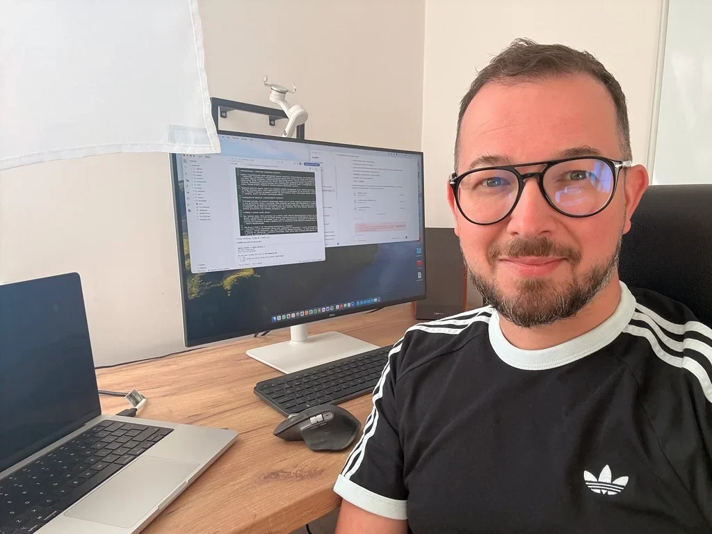 Robert Dobucki przy biurku z laptopem i monitorem.
